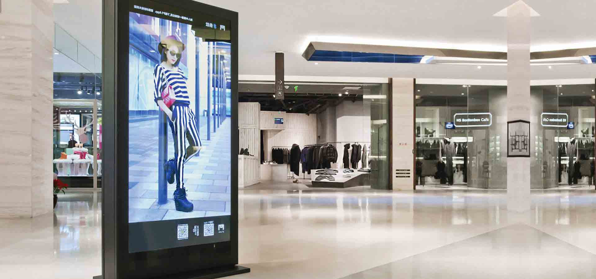 Fritstående infoskærm i indkøbscenter med reklame for mode