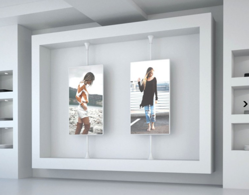 To dobbeltsidede displays ophængt i hvidt beslag fra loft til gulv.