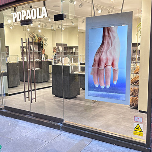 Hængende dobbeltsidet vinduesskærm i vindue til smykkebutik.