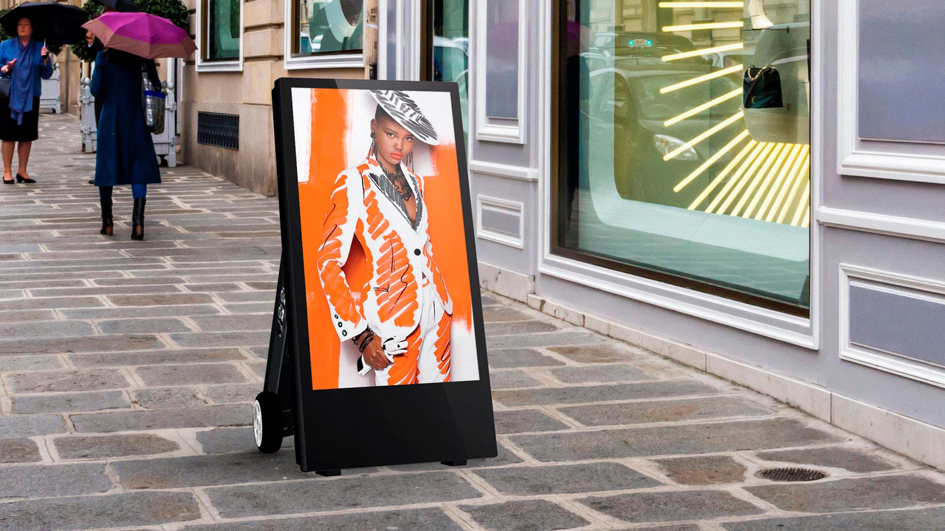 Batteridrevet A-skilt med digital skærm, der viser reklame, placeret på en gågade.