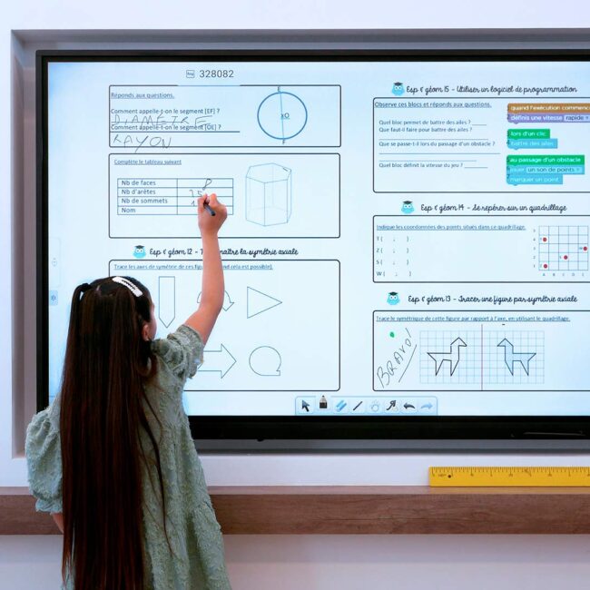 Elever løser opgaver på et interaktivt Speechi smartboard til undervisning og møder.