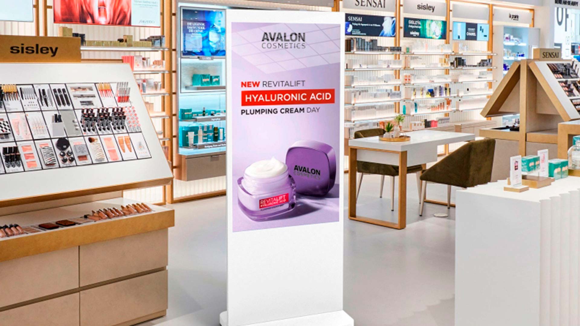 Fritstående digital skærm med kosmetikreklame i en skønhedsbutik.