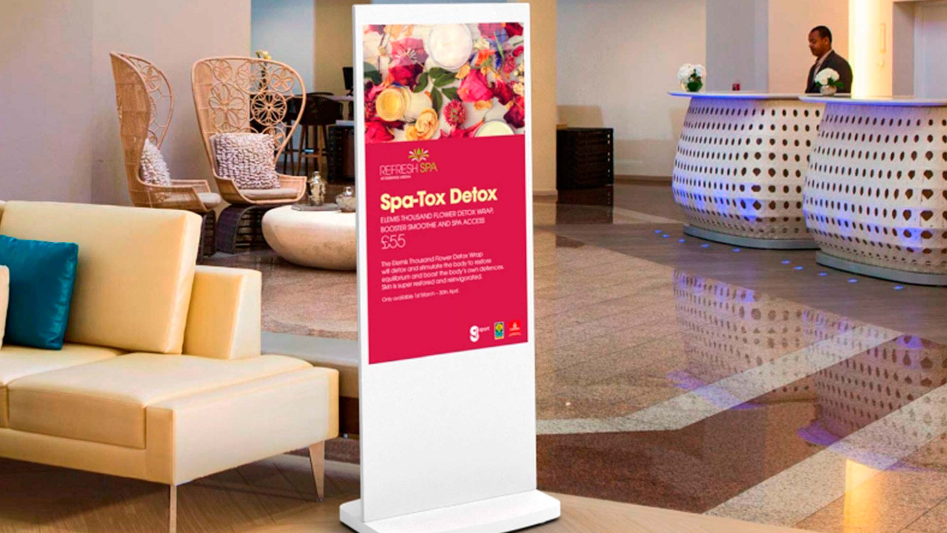 Fritstående digitalt display med reklame for spa i et hotel lobbyområde.