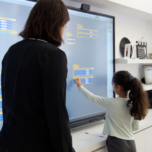 Lærer bruger smartboard til undervisning for at forklare komplekse emner til eleverne.