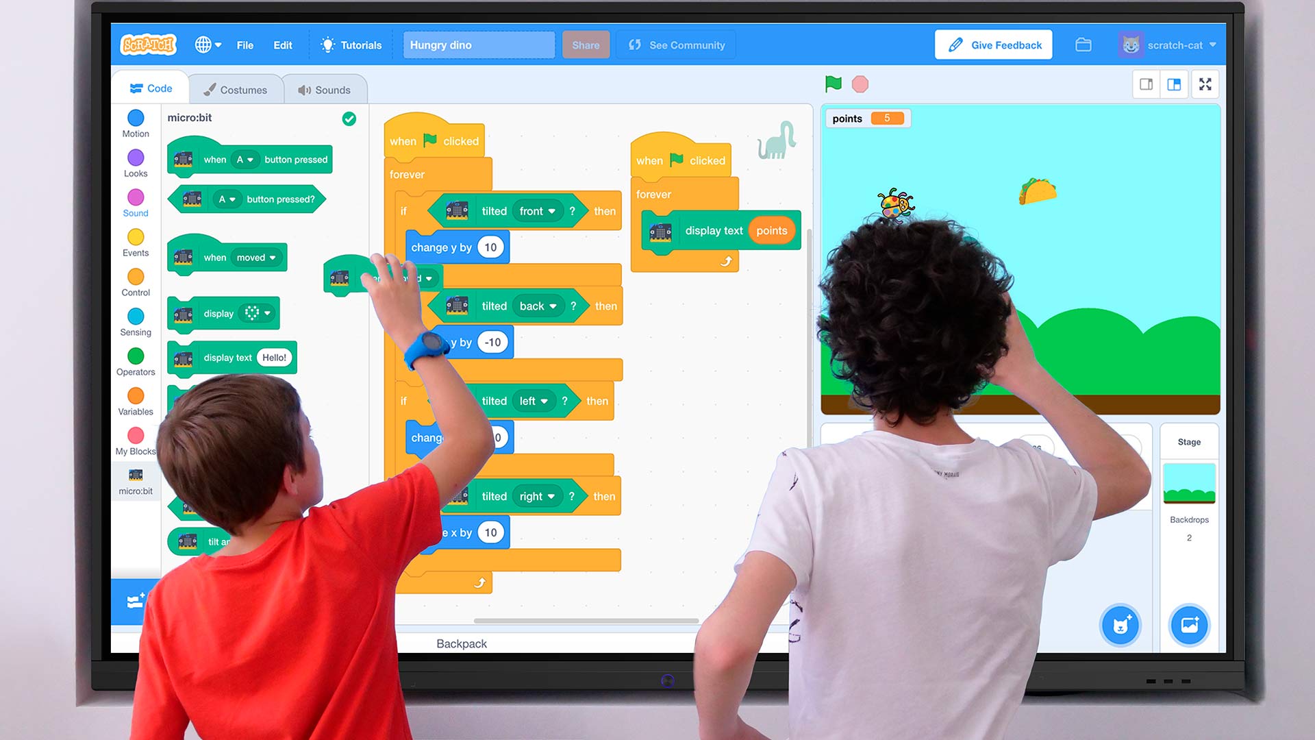To elever arbejder på et Speechi smartboard og lærer programmering i klasseværelset.