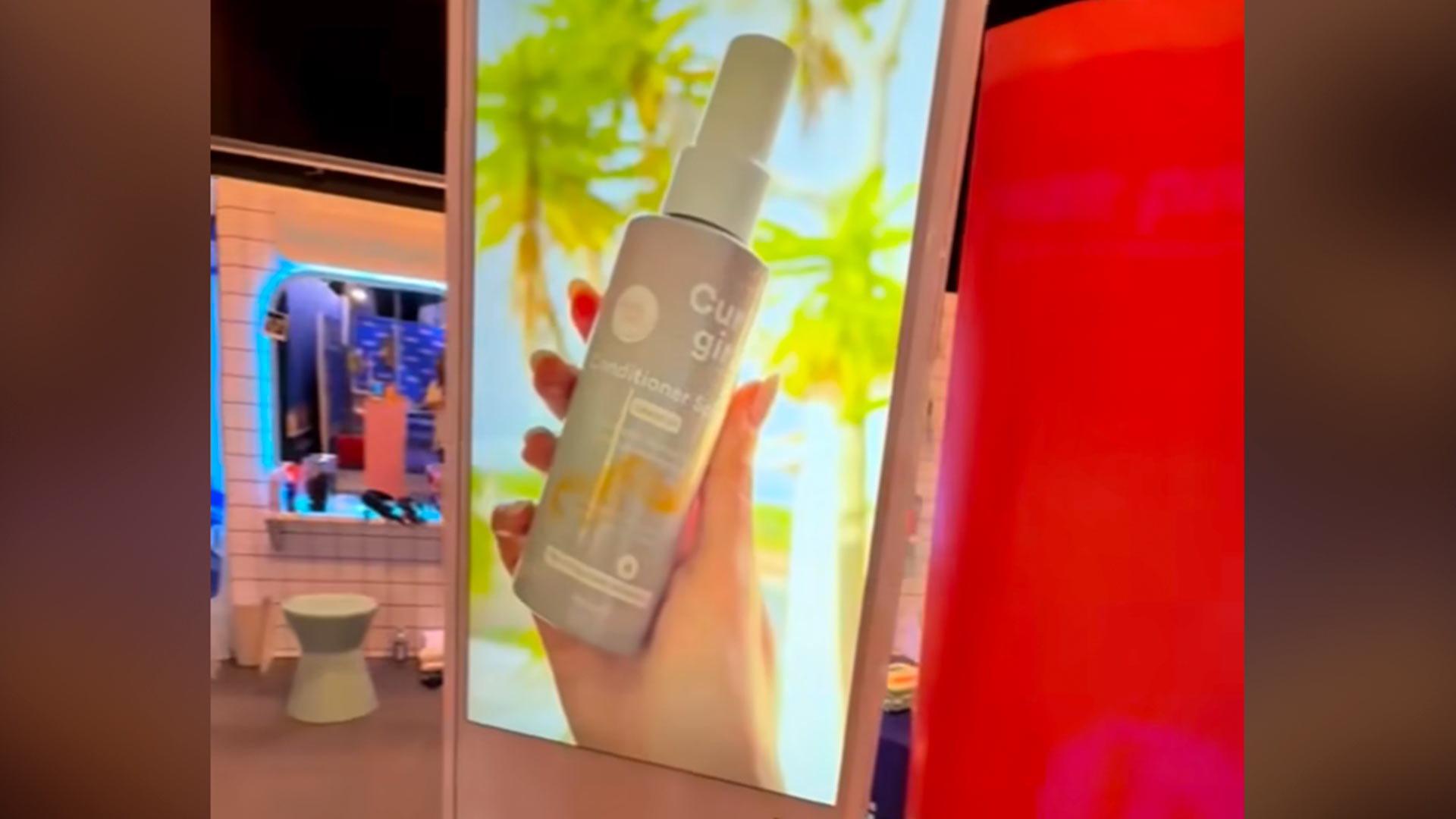 Stor lodret skærm med reklame for "Curl girl" produkt til hår.