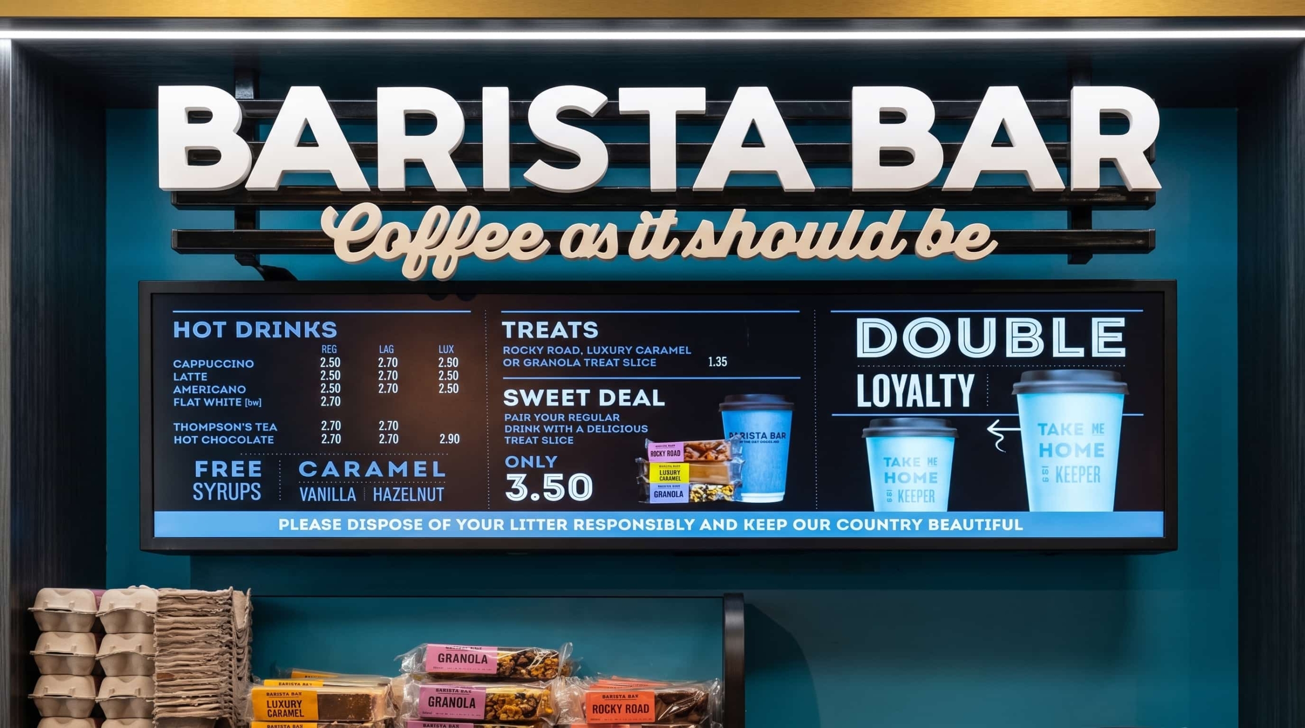 Stretched display monterat ovanför disken på kaféet, som visar priser och erbjudanden