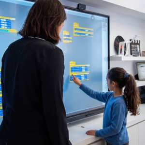 Lærer bruger smartboard til undervisning for at forklare komplekse emner til eleverne.