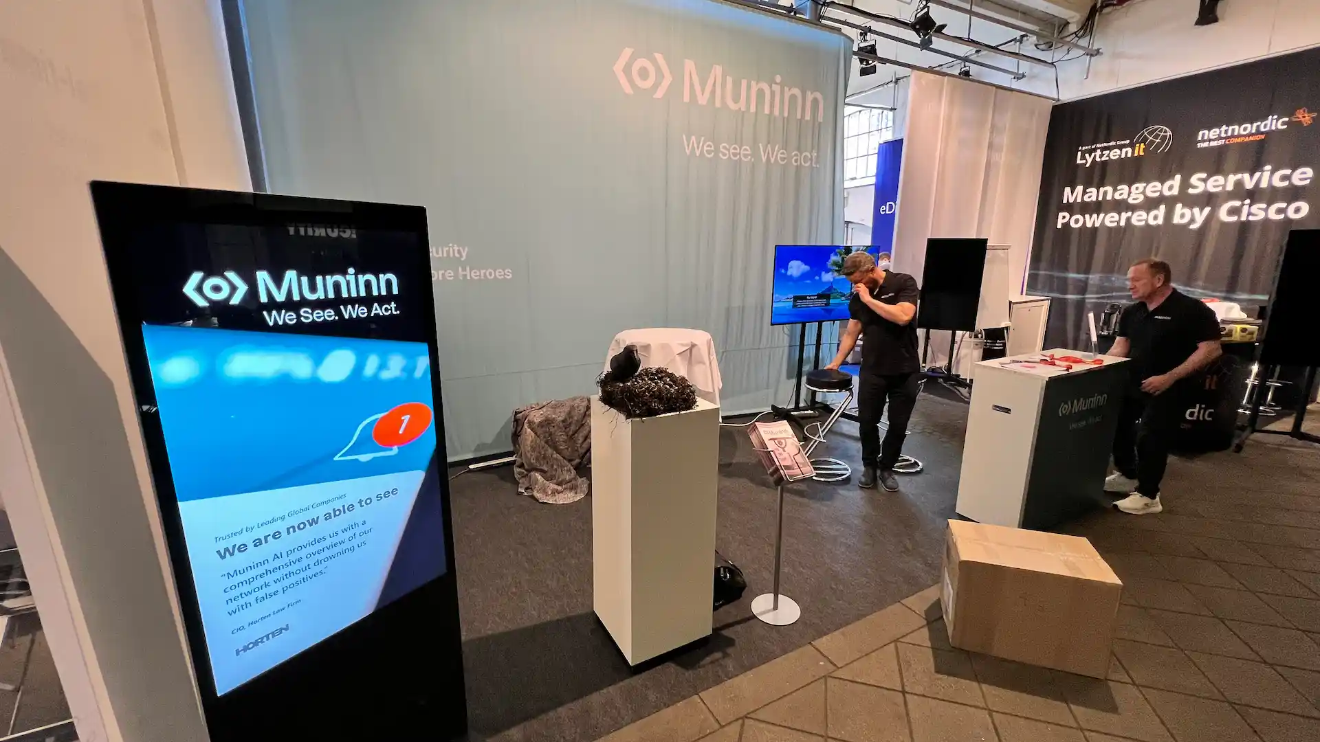 Medarbejdere fra Visual Display sætter interaktivt touch display op på Muninns messestand til V2 Security