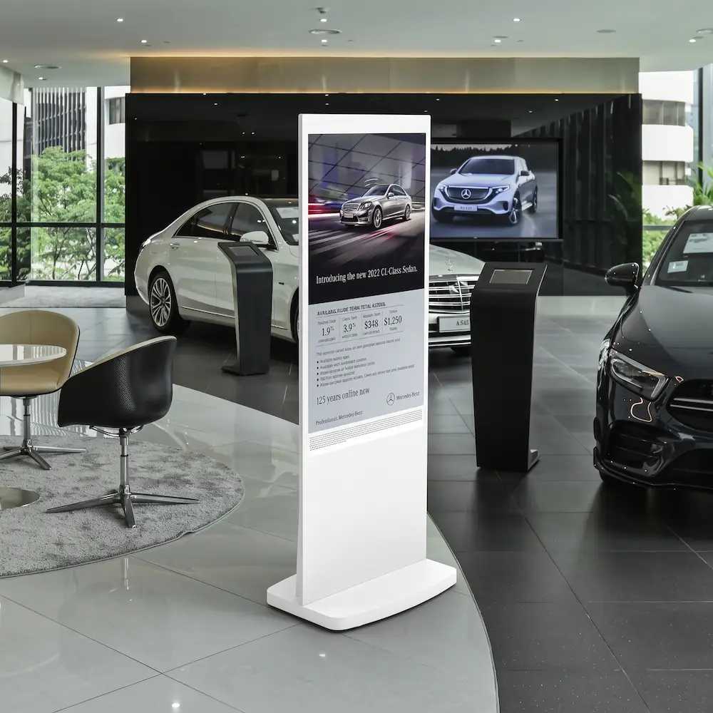 Hvid totem-skærm hos autoforhandler viser reklamer for biler