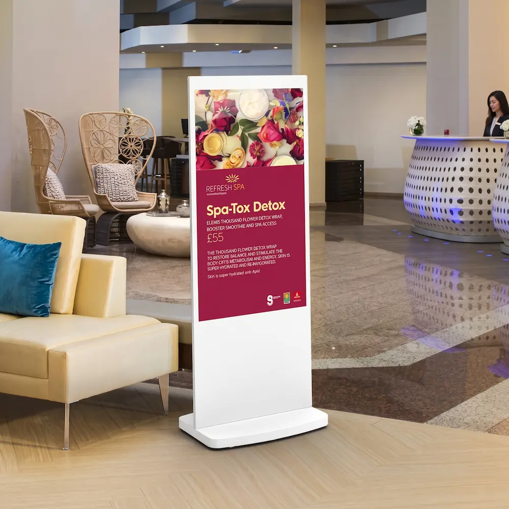 Nærbillede af hvid digital totem poster med Android i hotellobby med spareklame på skærmen