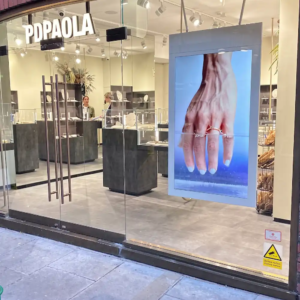 Hængende dobbeltsidet vinduesskærm i vinduet hos en smykkebutik