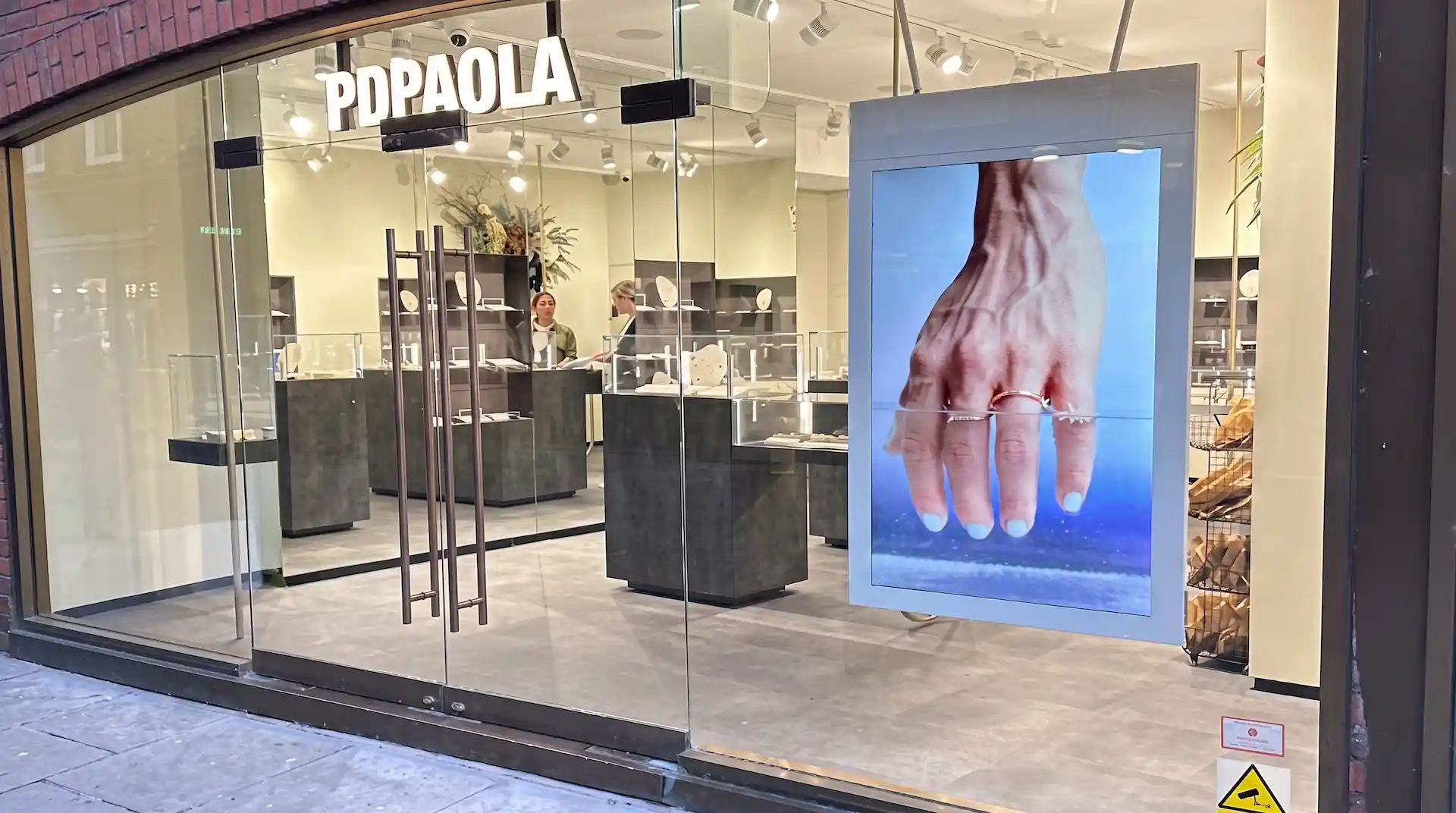 Hängande dubbelsidig fönsterskärm i fönstret på en juvelerarbutik