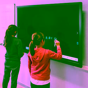 To elever øver bogstaver på et smartboard i skolen